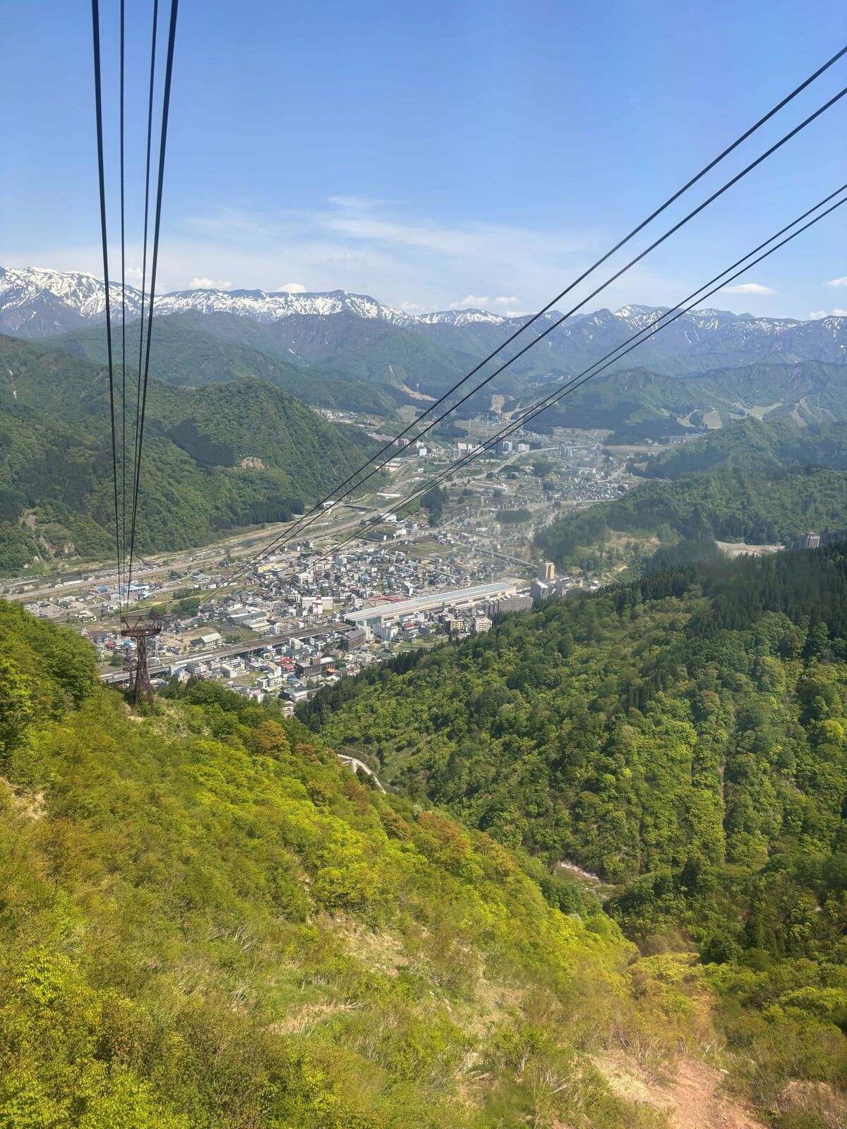 湯沢高原ロープウェイから見下ろす越後湯沢の街と残雪の山々